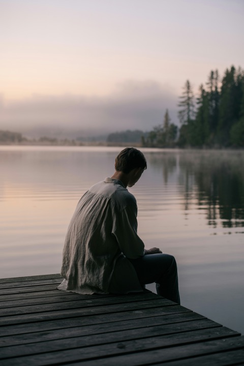 Someone sitting quietly by a lake